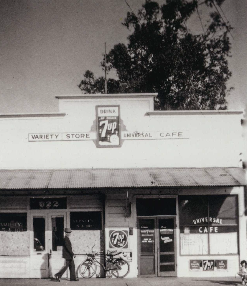 A black and white photo of a storefront that says "Universal Cafe"