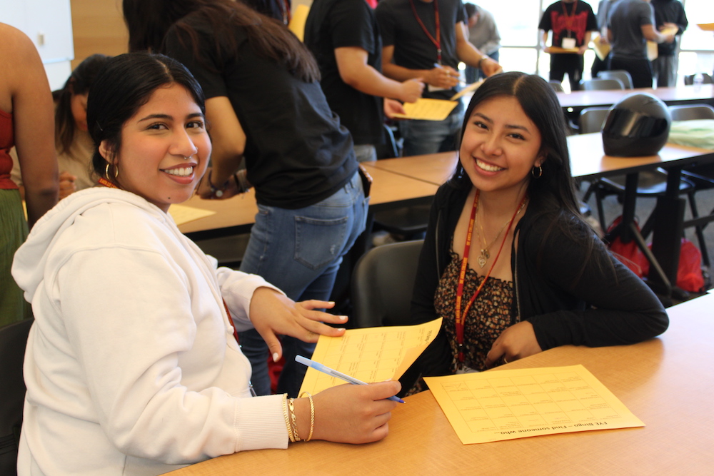 two young women smiling at table